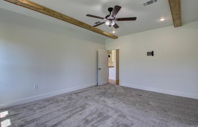 spare room featuring ceiling fan, beamed ceiling, and carpet