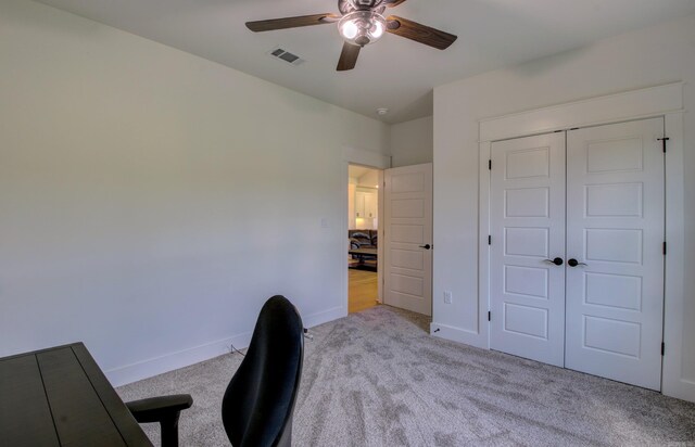 unfurnished office featuring light carpet and ceiling fan