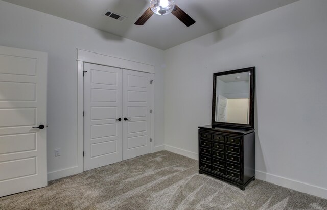 unfurnished bedroom with light carpet, ceiling fan, and a closet