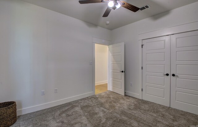 unfurnished bedroom with ceiling fan, light colored carpet, and a closet