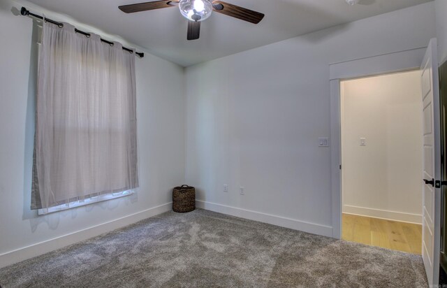 carpeted empty room featuring ceiling fan