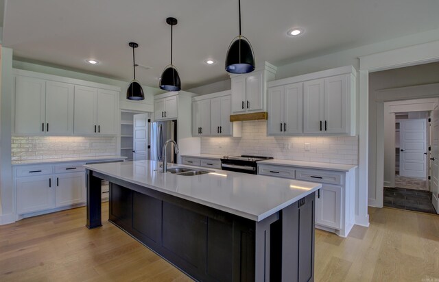 kitchen with pendant lighting, appliances with stainless steel finishes, and white cabinetry