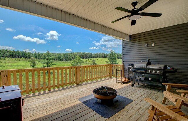 wooden terrace with ceiling fan and an outdoor fire pit