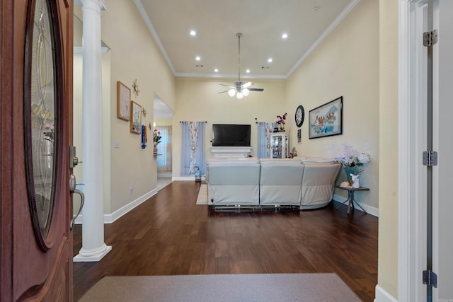 entrance foyer featuring crown molding, decorative columns, ceiling fan, and dark wood-type flooring