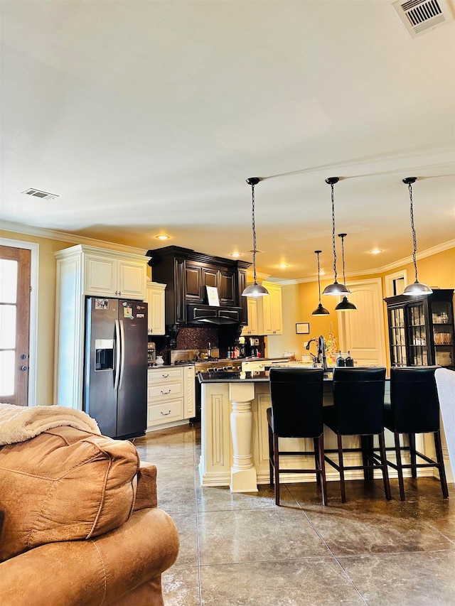 kitchen featuring a kitchen breakfast bar, decorative backsplash, crown molding, decorative light fixtures, and stainless steel fridge with ice dispenser