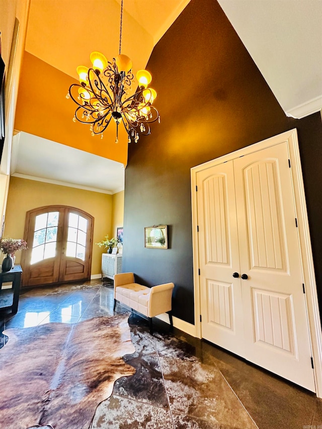 foyer featuring french doors, a notable chandelier, ornamental molding, and high vaulted ceiling