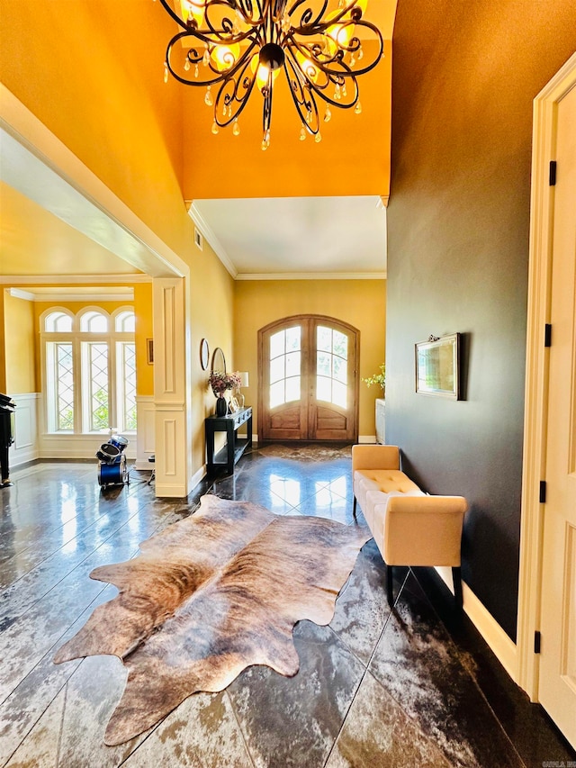 entryway featuring an inviting chandelier, french doors, and crown molding