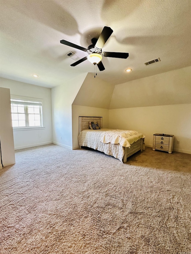 unfurnished bedroom with lofted ceiling, ceiling fan, carpet flooring, and a textured ceiling