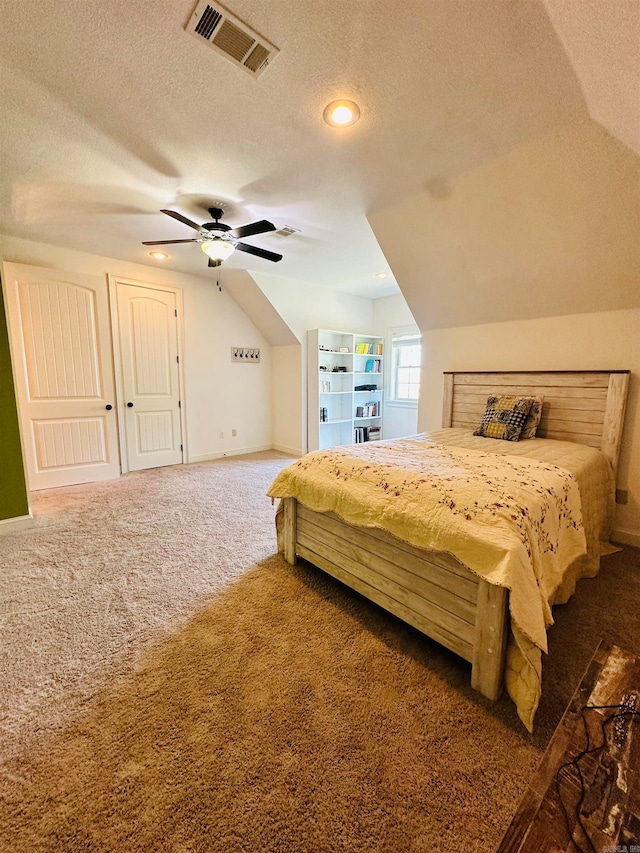 bedroom featuring dark carpet, vaulted ceiling, ceiling fan, and a textured ceiling