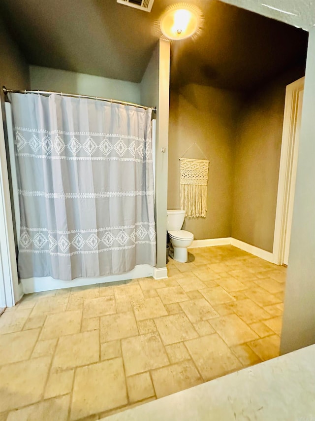 bathroom featuring walk in shower and toilet