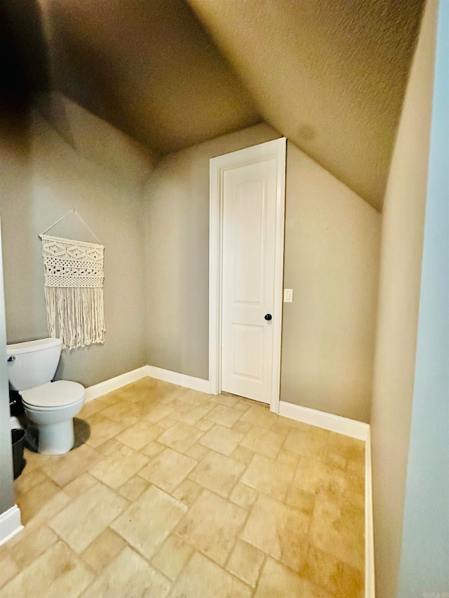 bathroom featuring lofted ceiling and toilet