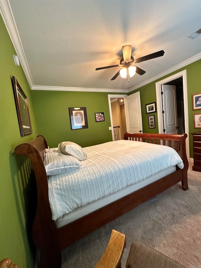 carpeted bedroom with a textured ceiling, ceiling fan, and crown molding