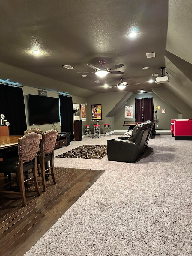 interior space featuring wood-type flooring, lofted ceiling, ceiling fan, and a textured ceiling