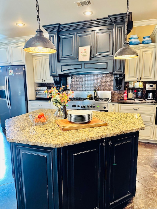 kitchen featuring ornamental molding, a kitchen island, appliances with stainless steel finishes, dark stone counters, and decorative backsplash