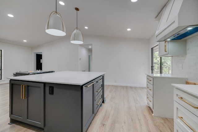 kitchen featuring gray cabinetry, white cabinets, a center island, and hanging light fixtures