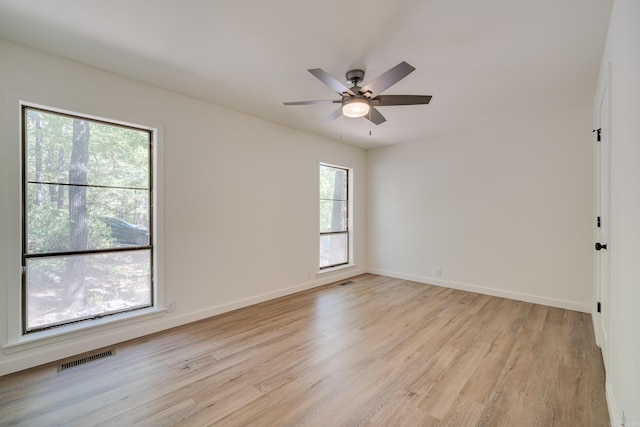 empty room with ceiling fan, light wood-type flooring, and plenty of natural light