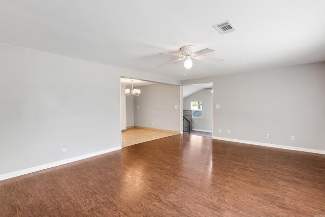 spare room with ceiling fan with notable chandelier and hardwood / wood-style floors