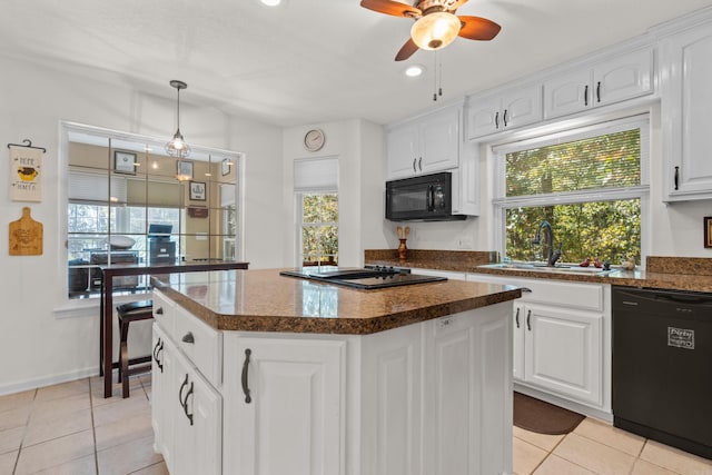 kitchen with ceiling fan, light tile patterned floors, black appliances, a kitchen island, and a sink