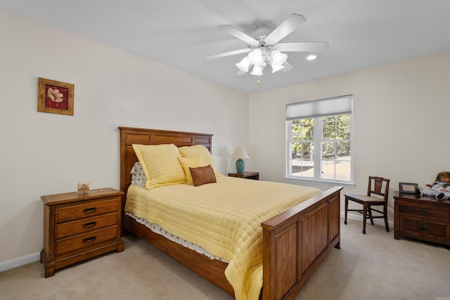 bedroom with ceiling fan, light carpet, and baseboards