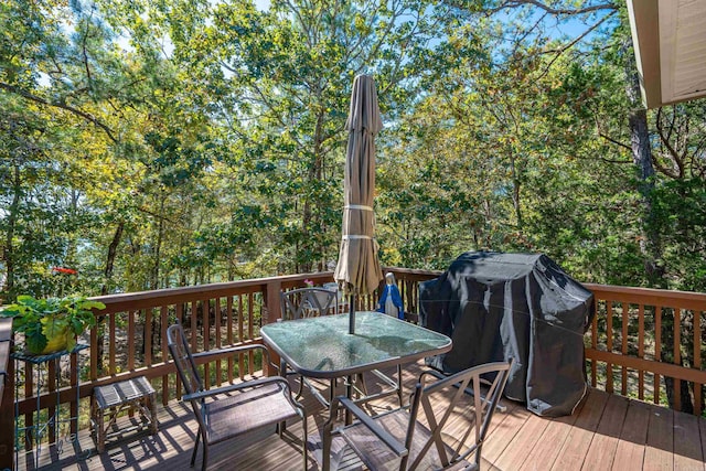 wooden terrace with outdoor dining area and a grill