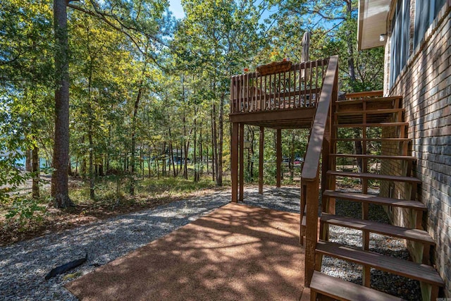 wooden terrace featuring stairway and driveway