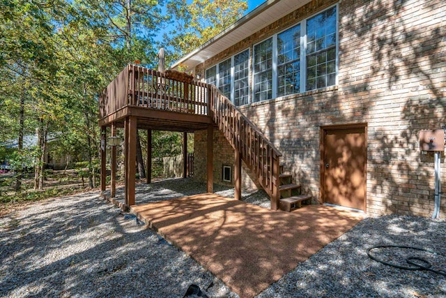 rear view of property with a patio area, a wooden deck, and stairs