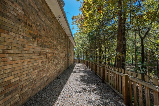 view of home's exterior with brick siding and fence