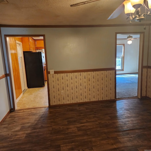 spare room with ceiling fan with notable chandelier, wood-type flooring, and a textured ceiling