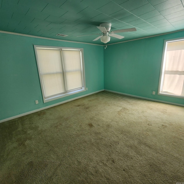 carpeted spare room featuring crown molding and ceiling fan