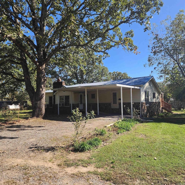 back of property with a lawn and a carport