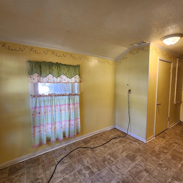 spare room with a textured ceiling and vaulted ceiling