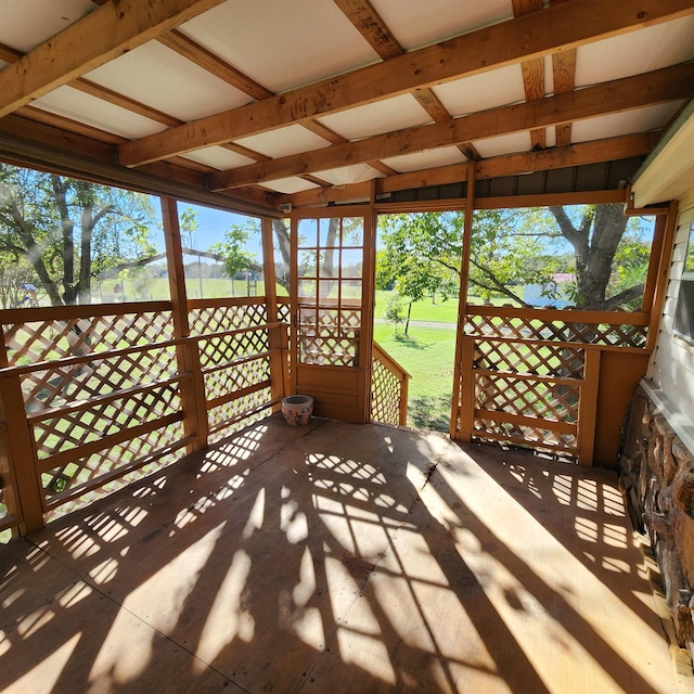 unfurnished sunroom featuring plenty of natural light and beam ceiling