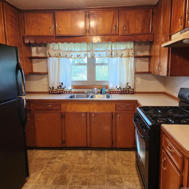 kitchen with a textured ceiling, black appliances, and sink