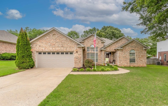 view of front of home with a garage, central air condition unit, and a front yard