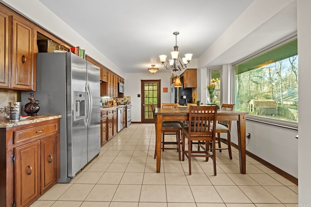 tiled dining area with an inviting chandelier and plenty of natural light