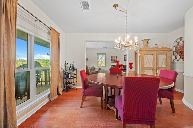 dining room featuring wood-type flooring and a chandelier