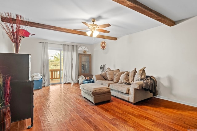 living room featuring wood-type flooring, ceiling fan, and beamed ceiling