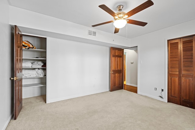 unfurnished bedroom featuring ceiling fan and light carpet