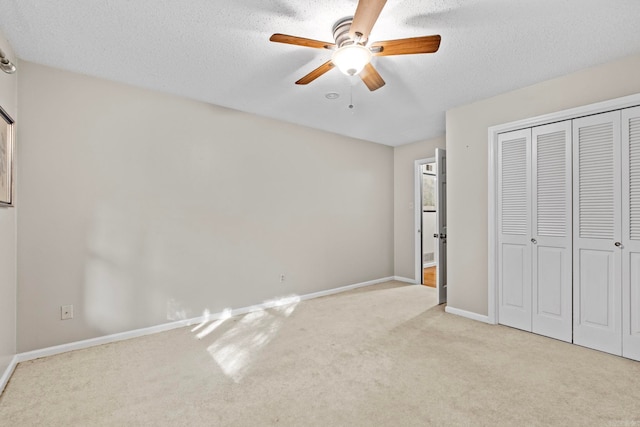 unfurnished bedroom with a textured ceiling, light carpet, ceiling fan, and a closet