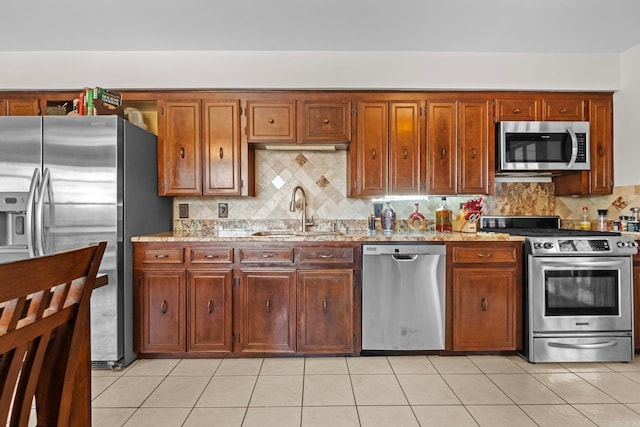 kitchen featuring backsplash, appliances with stainless steel finishes, light tile patterned floors, and sink