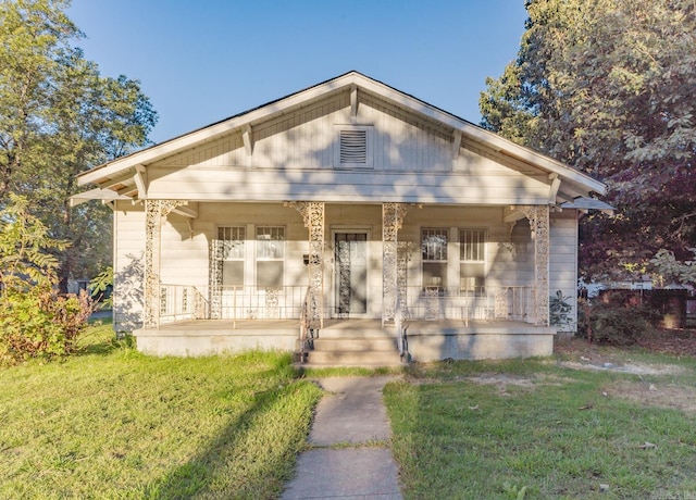 bungalow with a porch and a front lawn