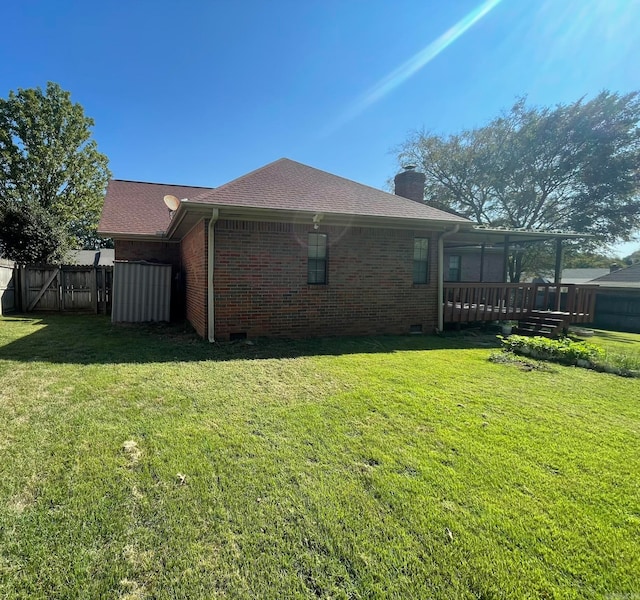 rear view of property with a deck and a lawn