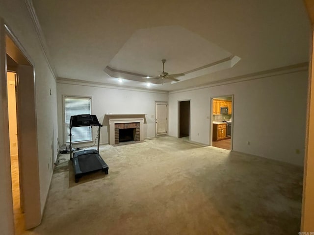 unfurnished living room with ceiling fan, a raised ceiling, and light carpet