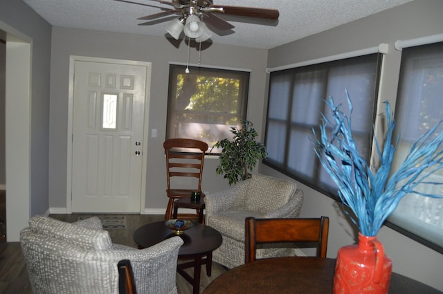 sitting room with ceiling fan, a textured ceiling, and hardwood / wood-style flooring