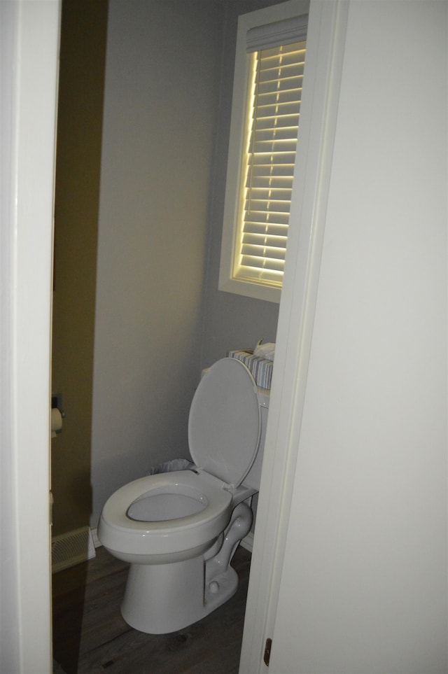 bathroom featuring wood-type flooring and toilet