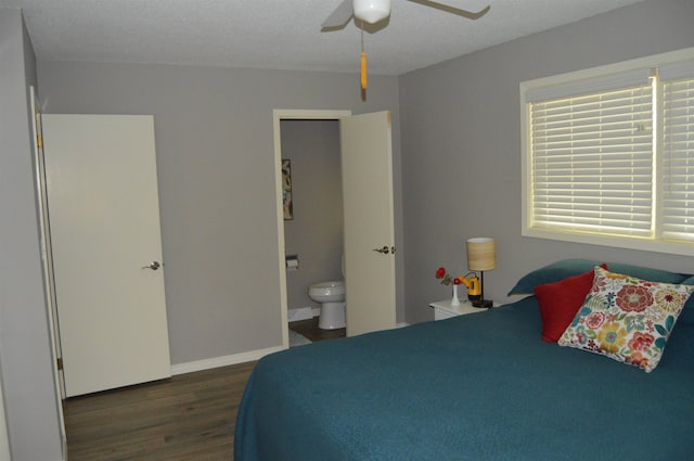 bedroom with a textured ceiling, dark hardwood / wood-style floors, ceiling fan, and ensuite bath