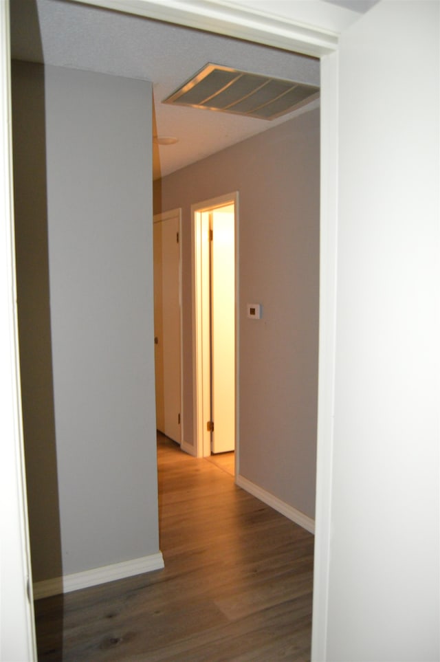 corridor with hardwood / wood-style floors