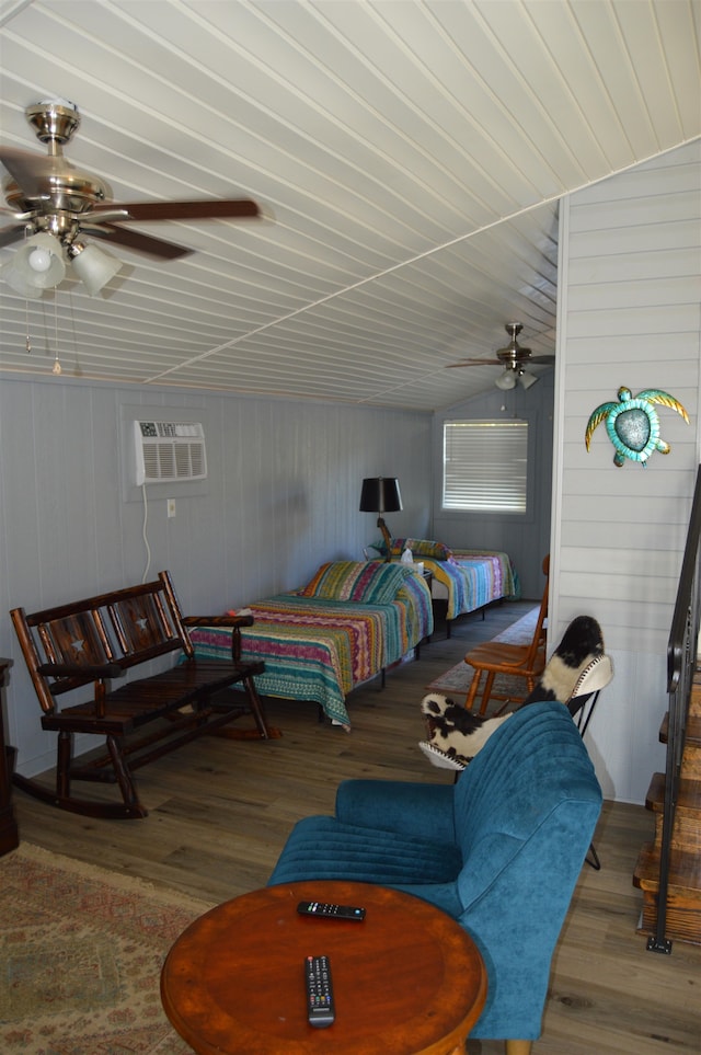 bedroom featuring vaulted ceiling, an AC wall unit, ceiling fan, and hardwood / wood-style flooring