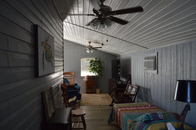 living room with wood-type flooring, lofted ceiling, wood walls, a wall mounted air conditioner, and ceiling fan