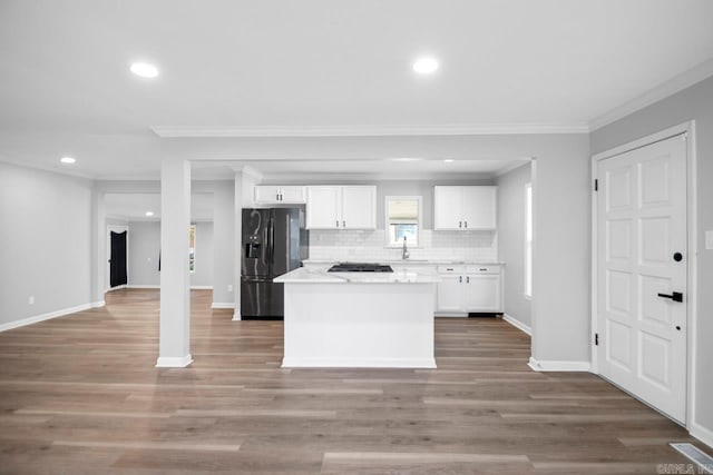 kitchen with black appliances, wood-type flooring, and white cabinets